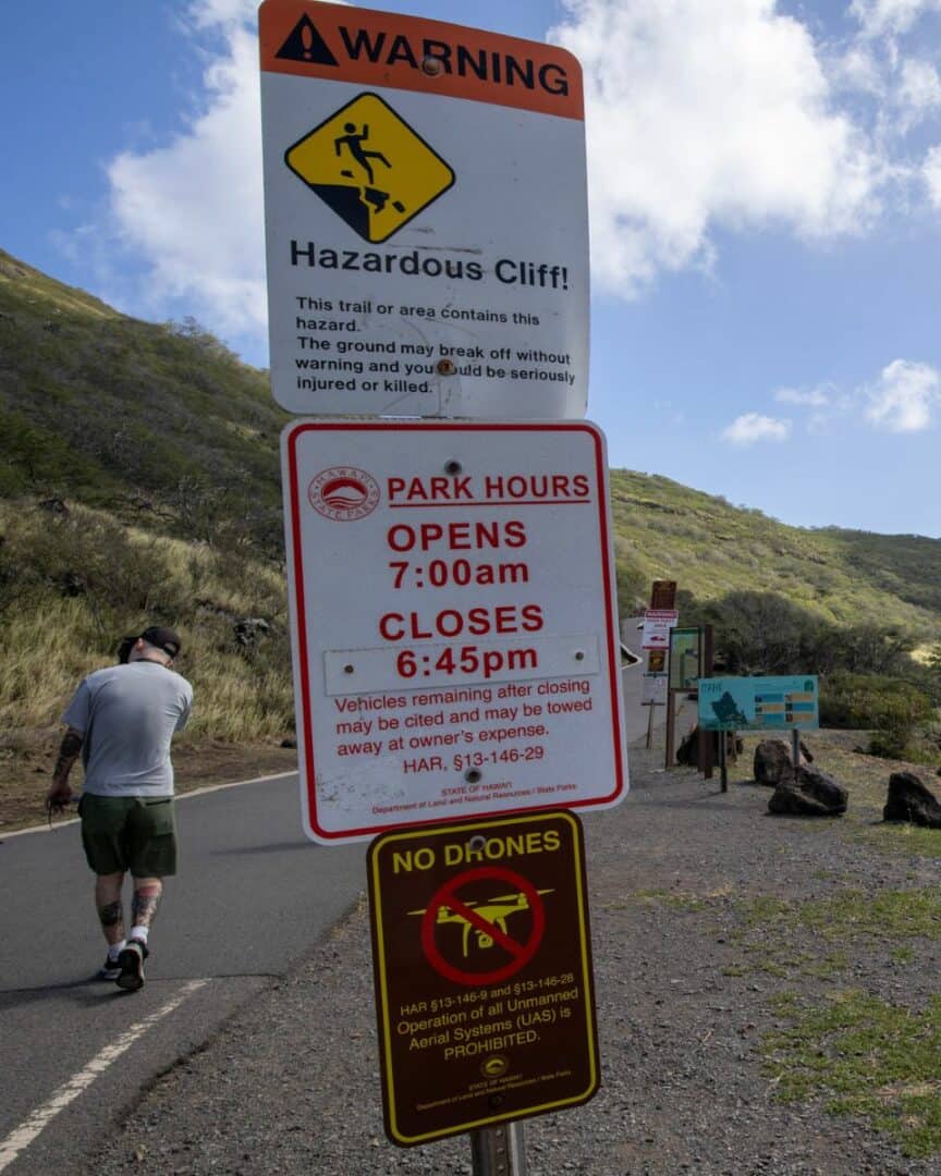 Hiking the Scenic Makapuu Lighthouse Trail 9 Warning signs at the beginning of the Makapuu Lighthouse Trail. Hazardous cliffs. Park hours.