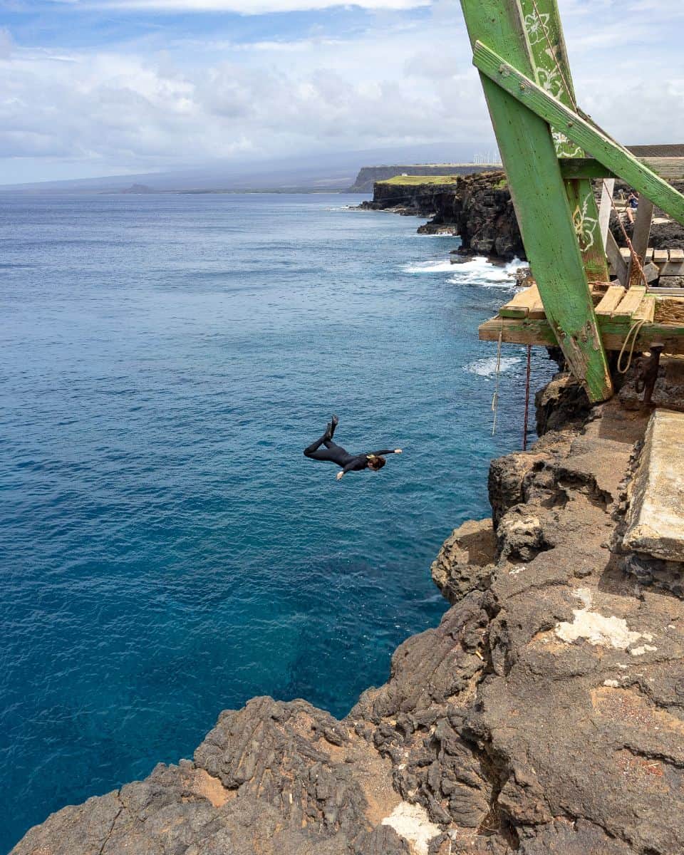 Man jumping off cliff at South Point Hawaii