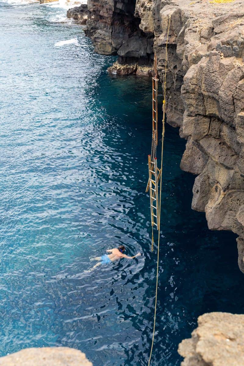 Man swimming in water at South Point Cliff Jump