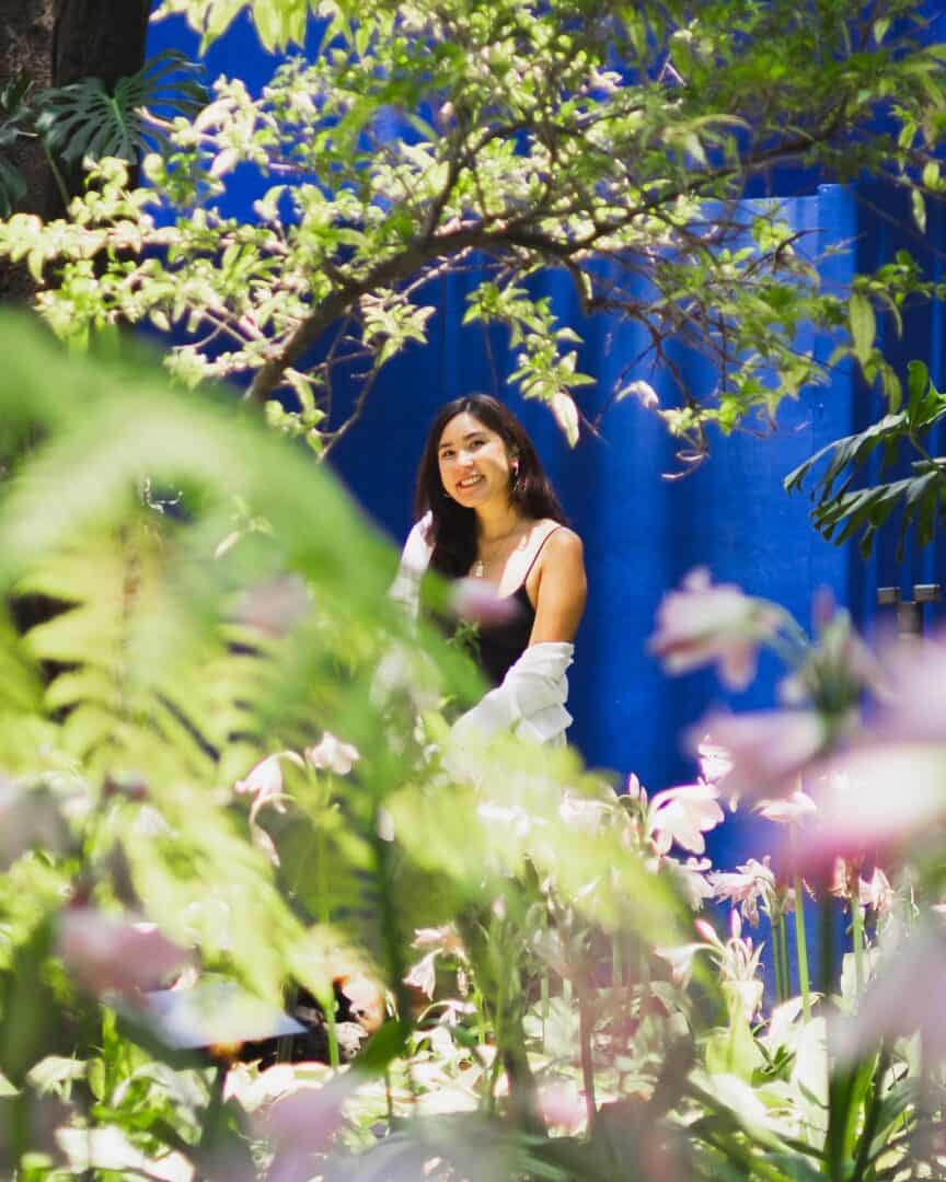 Chloe posing for an Instagram photo in the garden of the Frida Kahlo Museum in Mexico City