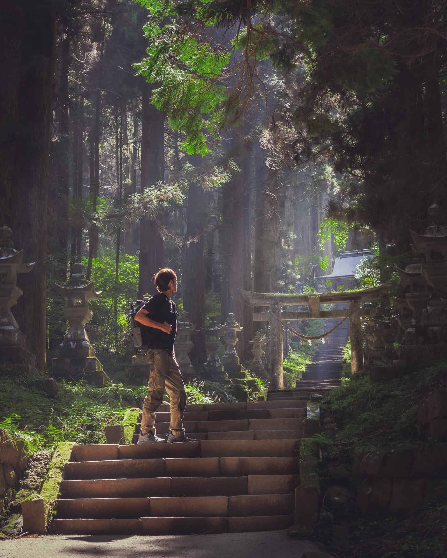 6 Incredible Things to Do in Mount Aso, Kyushu 8 Man on the steps of the Kamishikimi Kumanoimasu Shrine