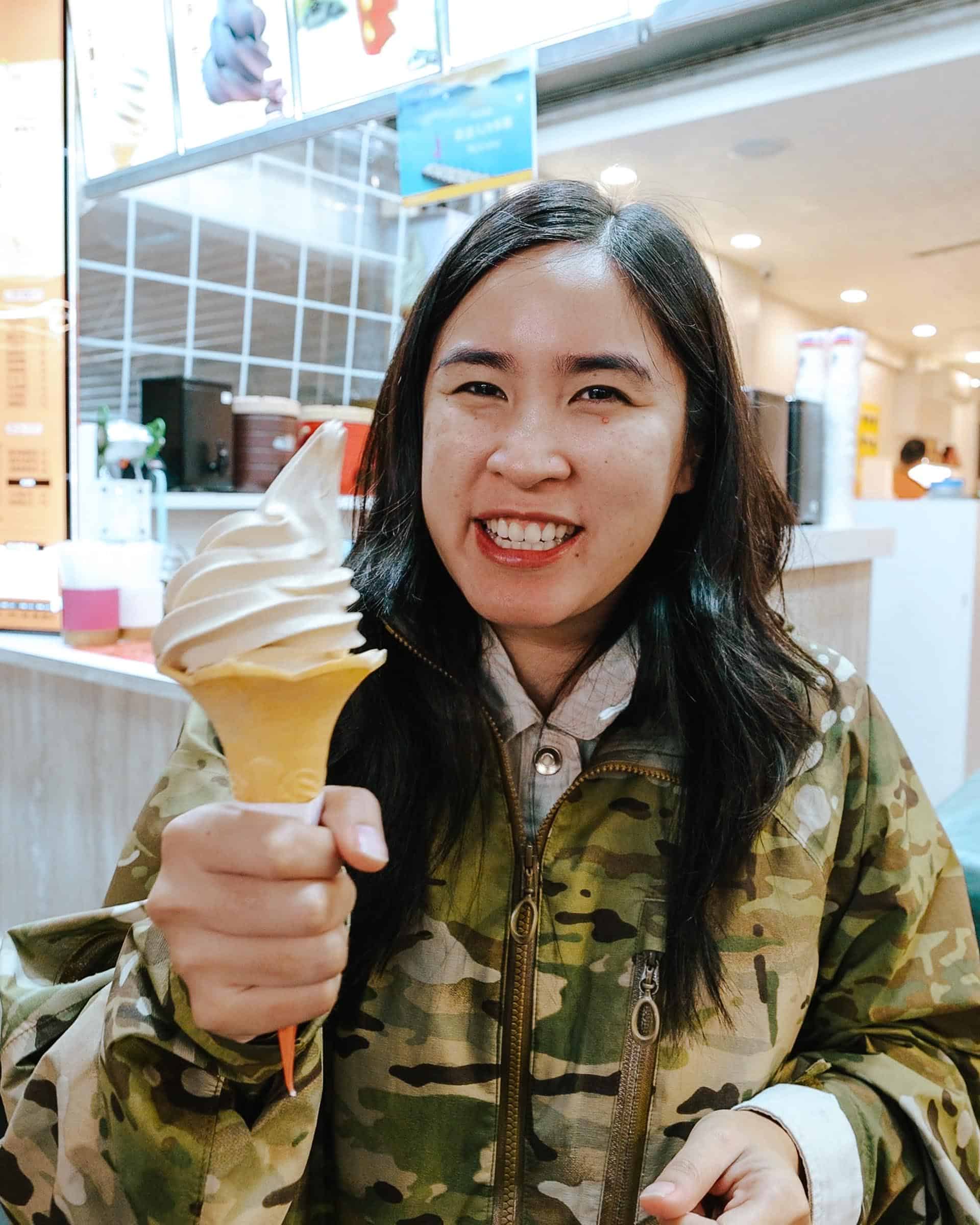Chloe eating green tea soft serve ice cream at Ita Thao Market