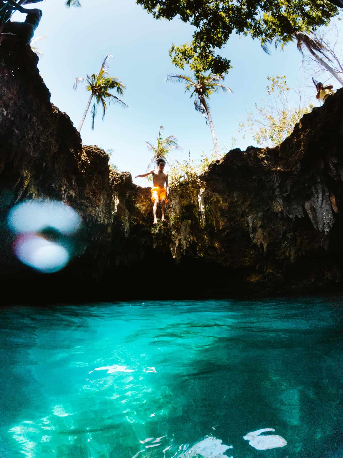 Man jumping inside of Cabagnow Cave Pool
