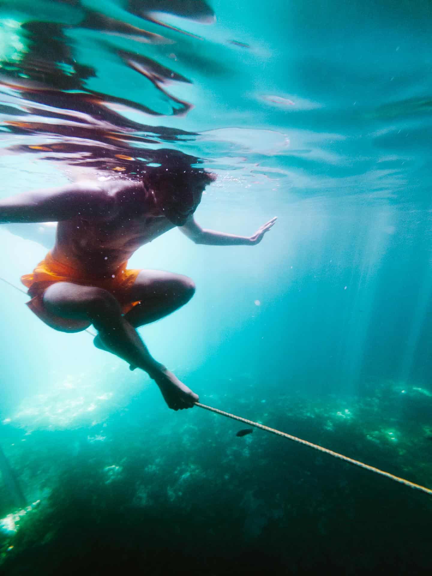 Trey balancing on rope inside Cabagnow Cave Pool