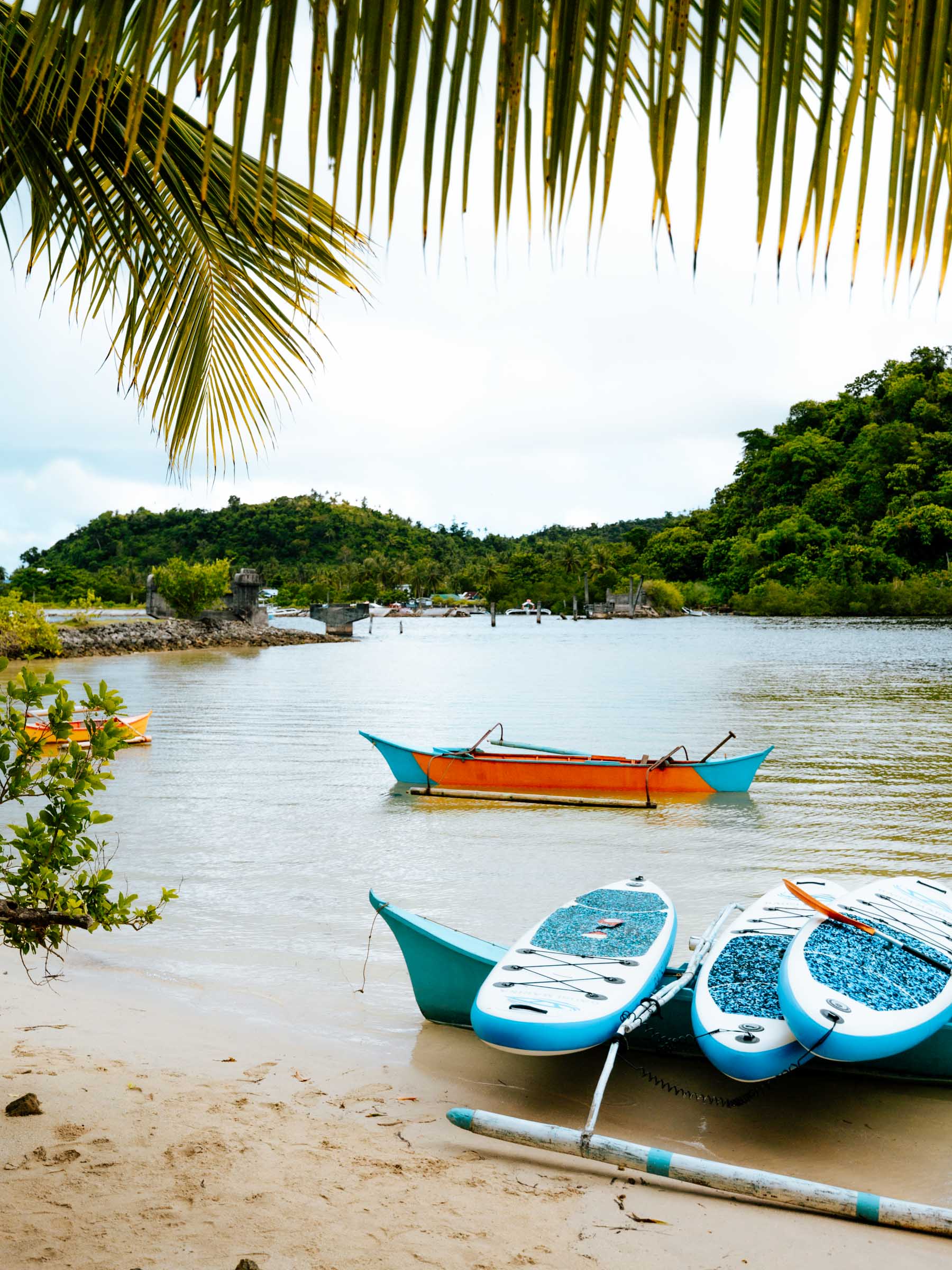 Paddleboards and canoe at Secret Beach Siargao